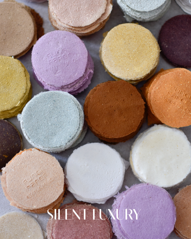 Round colour samples of handmade mycelium paper by Tanja Major in pastel, ochre, terracotta and white, demonstrating fungi based material experimentation as a compostable alternative to wood pulp and industrial fibre systems.