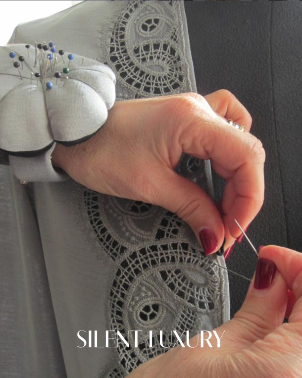 Hand finishing lace detail on the sleeve of a Filifolli garment