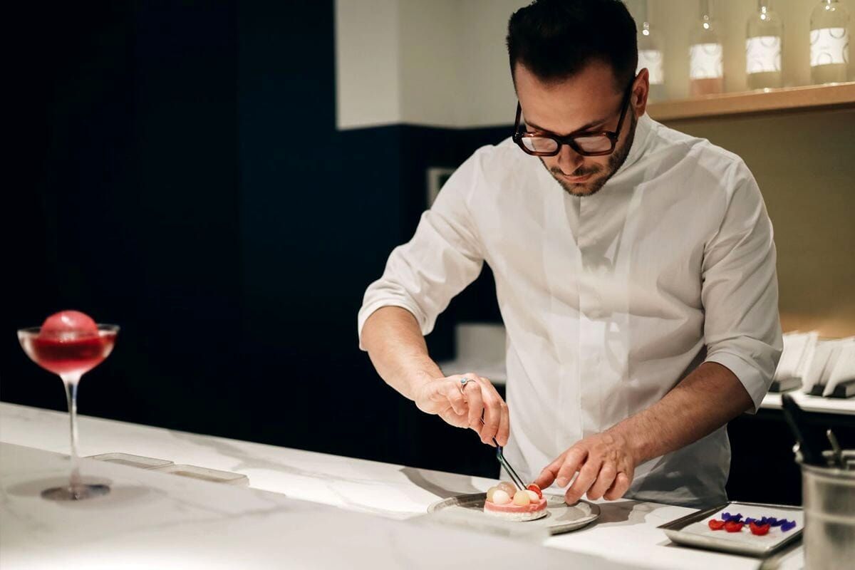 Federico Rottigni at the counter of Sensorium Milano, where preparation becomes part of a multisensory composition shaped by light, space and perception. | Photo: Sensorium Milano