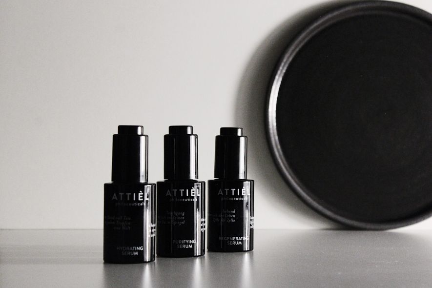 A trio of minimalist ATTIÈL philoceutical serums in sleek black glass bottles, capturing the essence of a refined and natural grooming ritual.