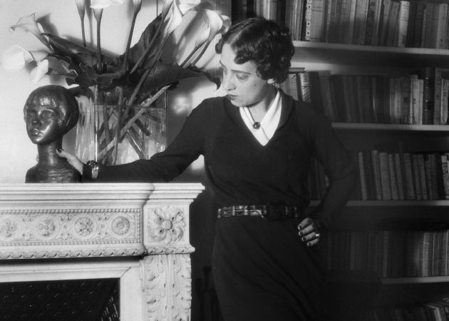 Elsa Schiaparelli at home, among books and arum lilies, 1936. Photograph by Boris Lipnitzki. Credit: APA-Images / Roger Viollet / Boris Lipnitzki.