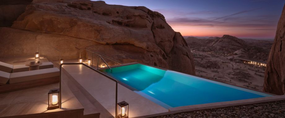Infinity pool at Desert Rock Resort, integrated into the rocky Hejaz Mountains landscape at sunset, symbolizing luxury, slow hospitality and architectural harmony with nature.