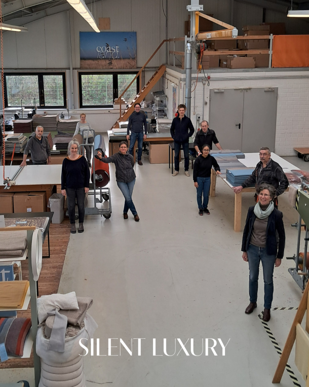 Coastland team in the textile workshop surrounded by blankets and looms