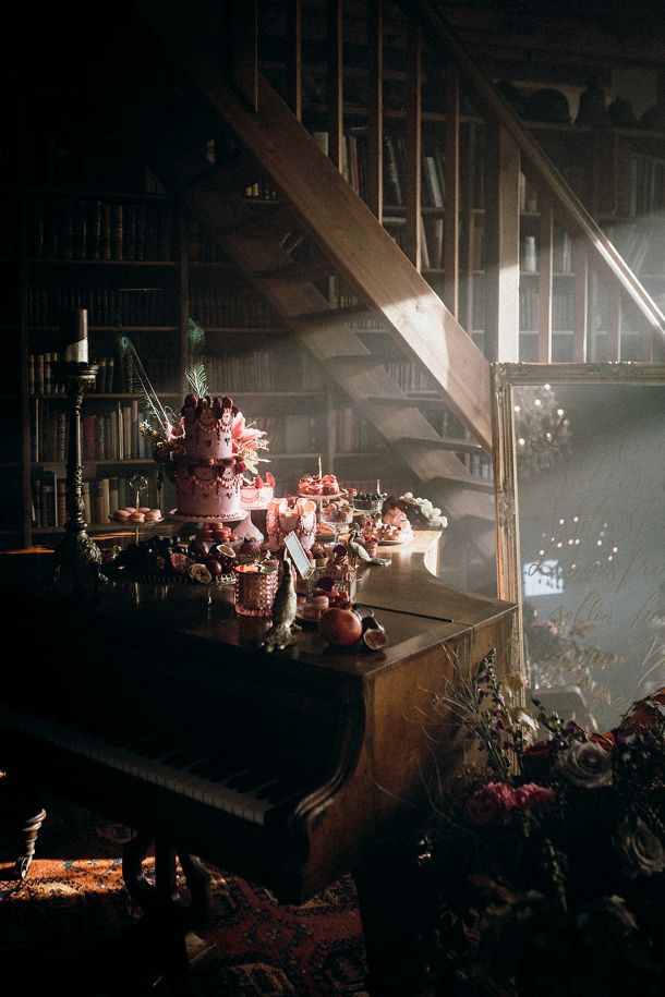 An atmospheric scene featuring a woman and a dramatic display of Dulcesserie pastry art on a black grand piano, embodying the "Extra Ordinary" luxury of the brand.