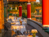 Aerial view of the Borgo La Pietraia terrace at sunset, guests dining above the plain of Paestum and the Tyrrhenian Sea, Cilento, southern Italy