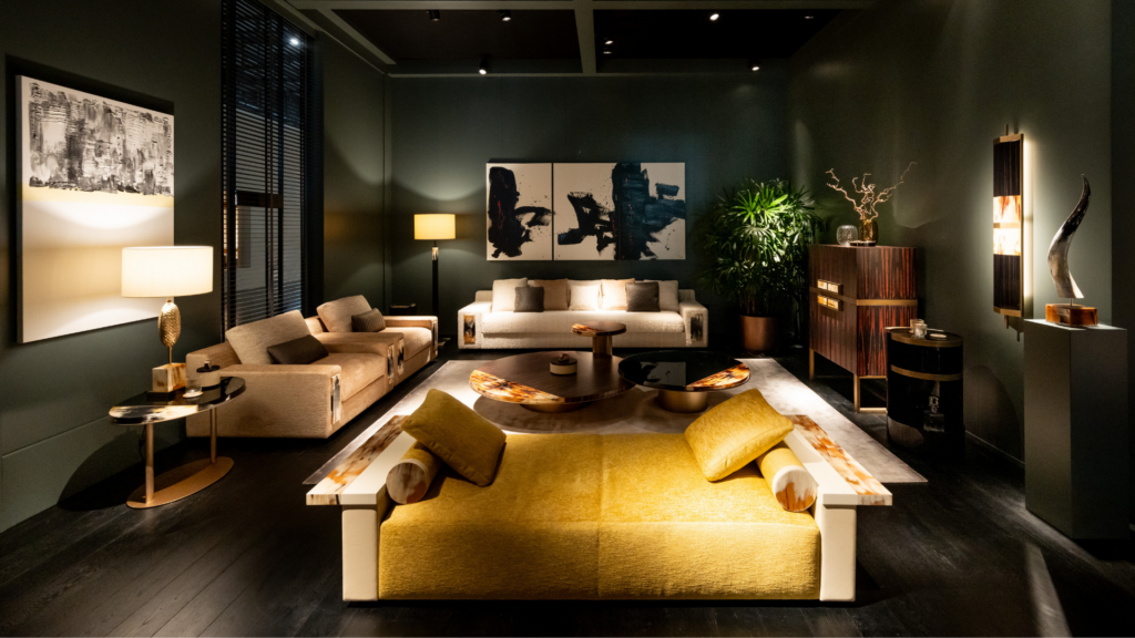 ARCAHORN stand at Salone del Mobile Milano 2026 — dark interior with golden yellow sofa and brass lamps