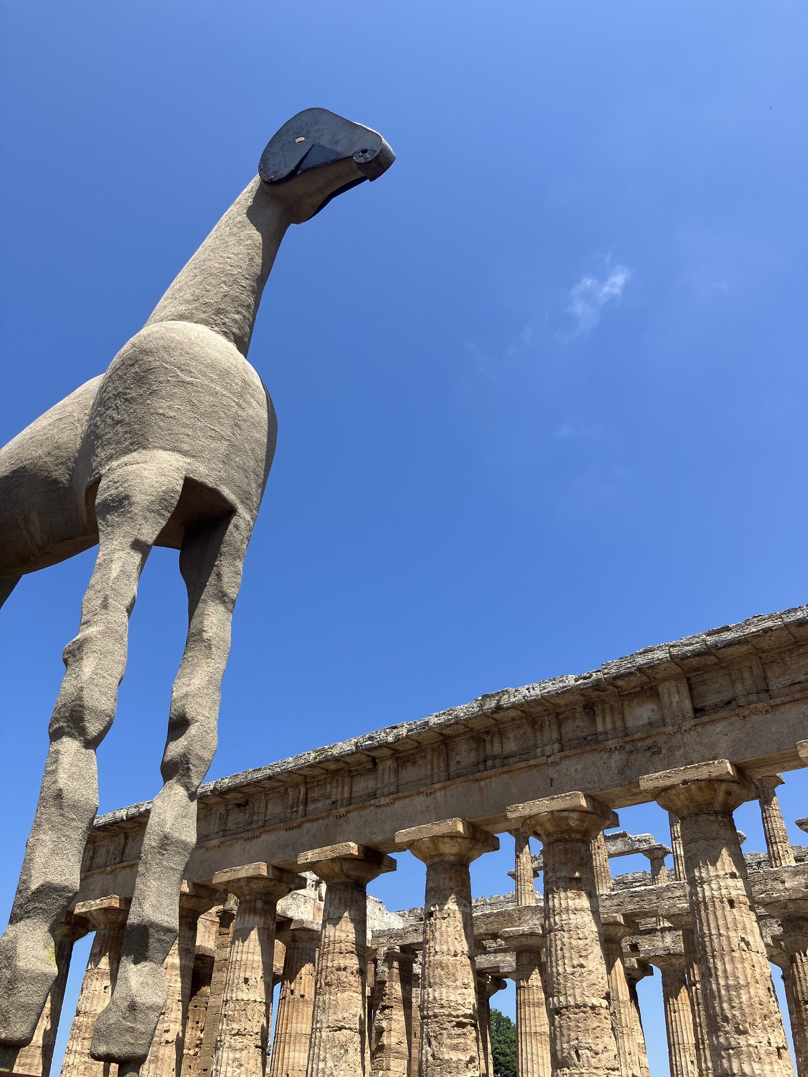 A sand sculpture of a horse before the columns of the Temple of Neptune at Paestum, the ancient Greek city of Poseidonia in the Cilento.