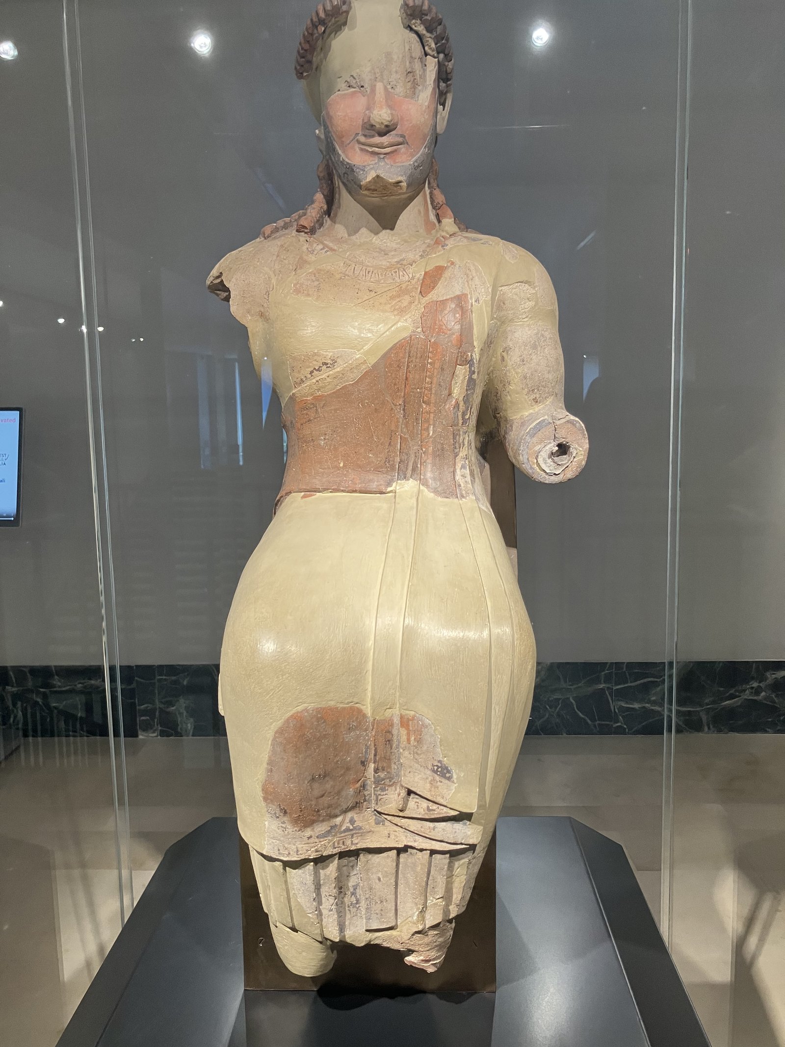 An archaic statue of Zeus in the National Archaeological Museum of Paestum, the face lifted in the archaic smile.