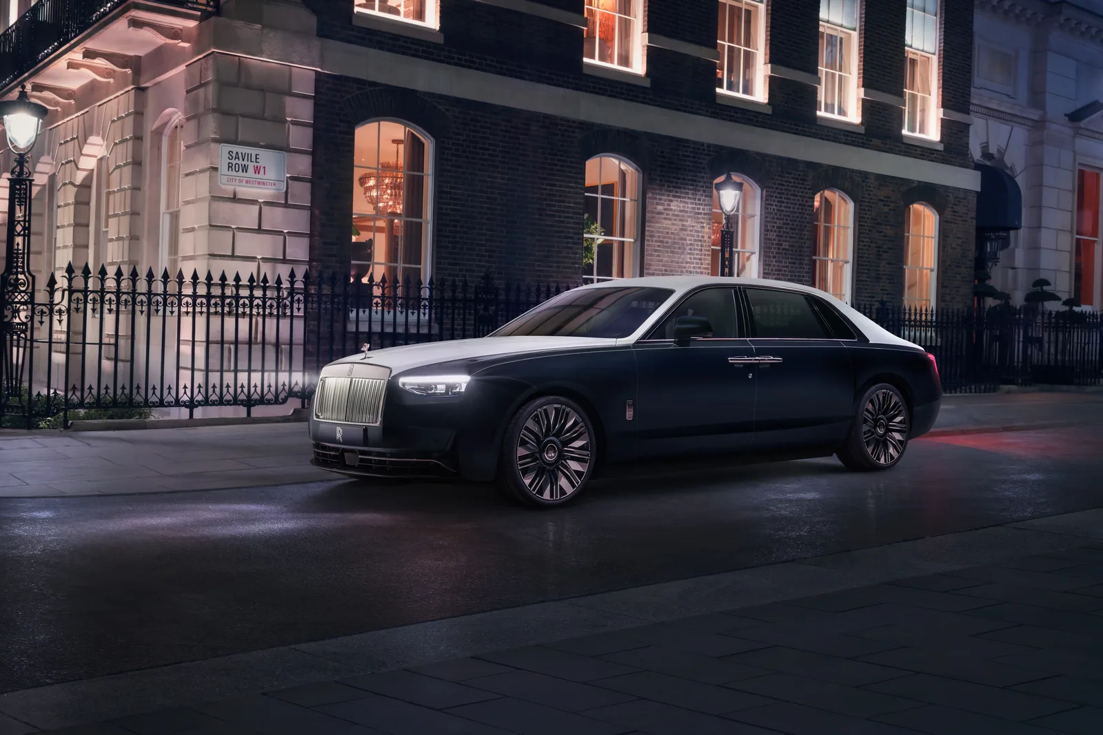 Rolls-Royce Ghost Savile Row in Midnight Sapphire and English White beside the Savile Row W1 street sign at night