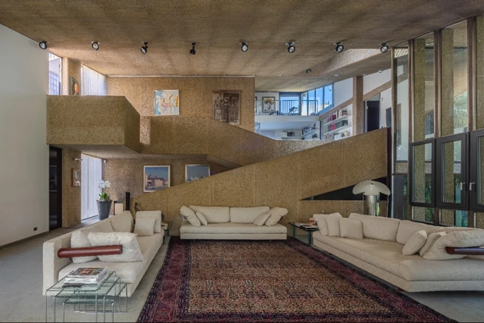 A cantilevered stair crosses above the living floor. Volume dominates mass, and the structure stays visible | Photo: Courtesy of Italy Sotheby’s International Realty