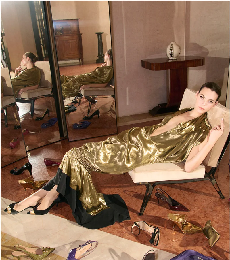 A model in a gold lamé gown reclines in a Florentine palazzo, surrounded by Ferragamo shoes from the Autumn/Winter 2026 collection. Footwear makes up 45 per cent of Ferragamo revenue.