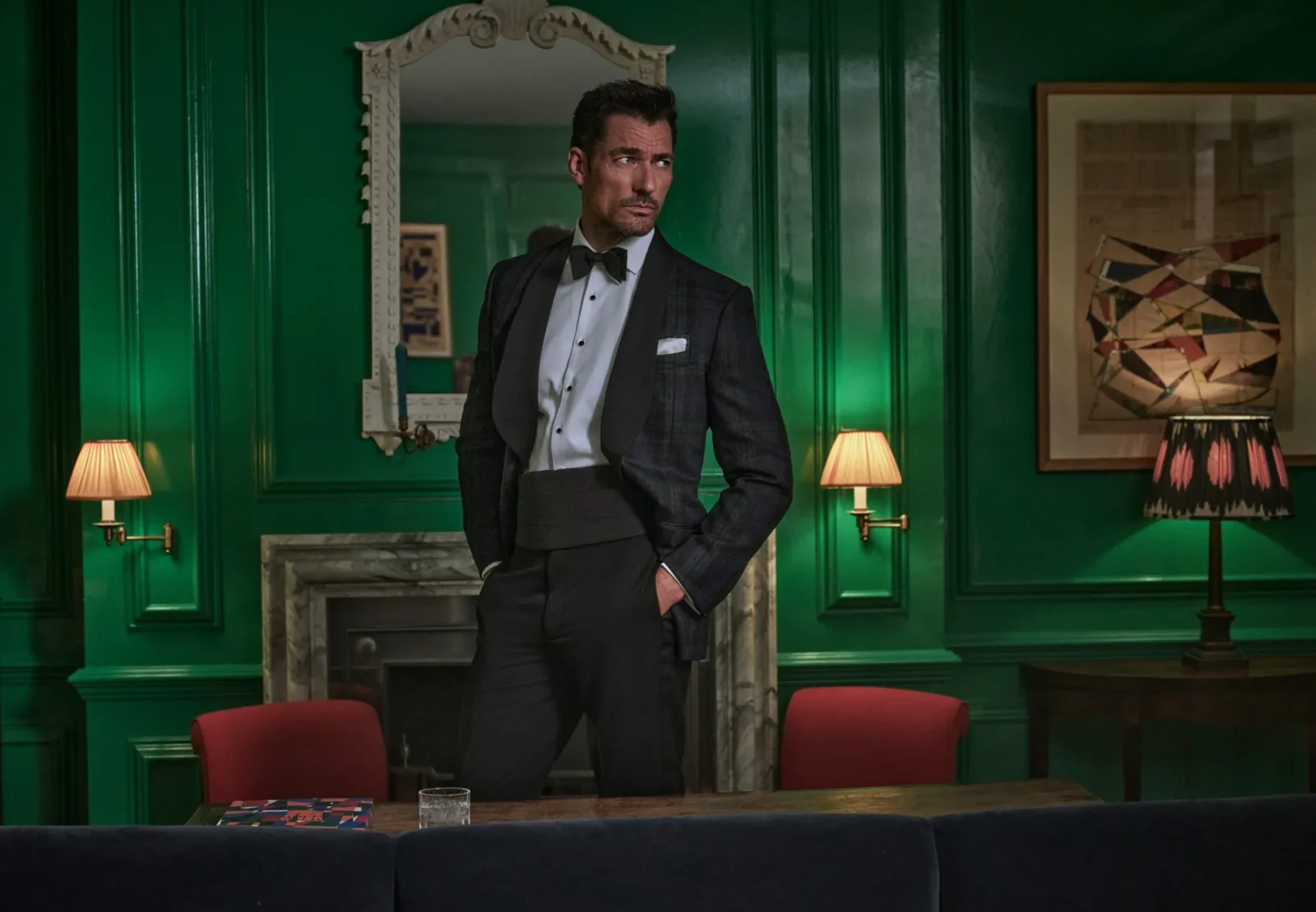 British model David Gandy in a black dinner suit from Hackett Nº14 Savile Row in a green panelled room. Courtesy of Hackett London
