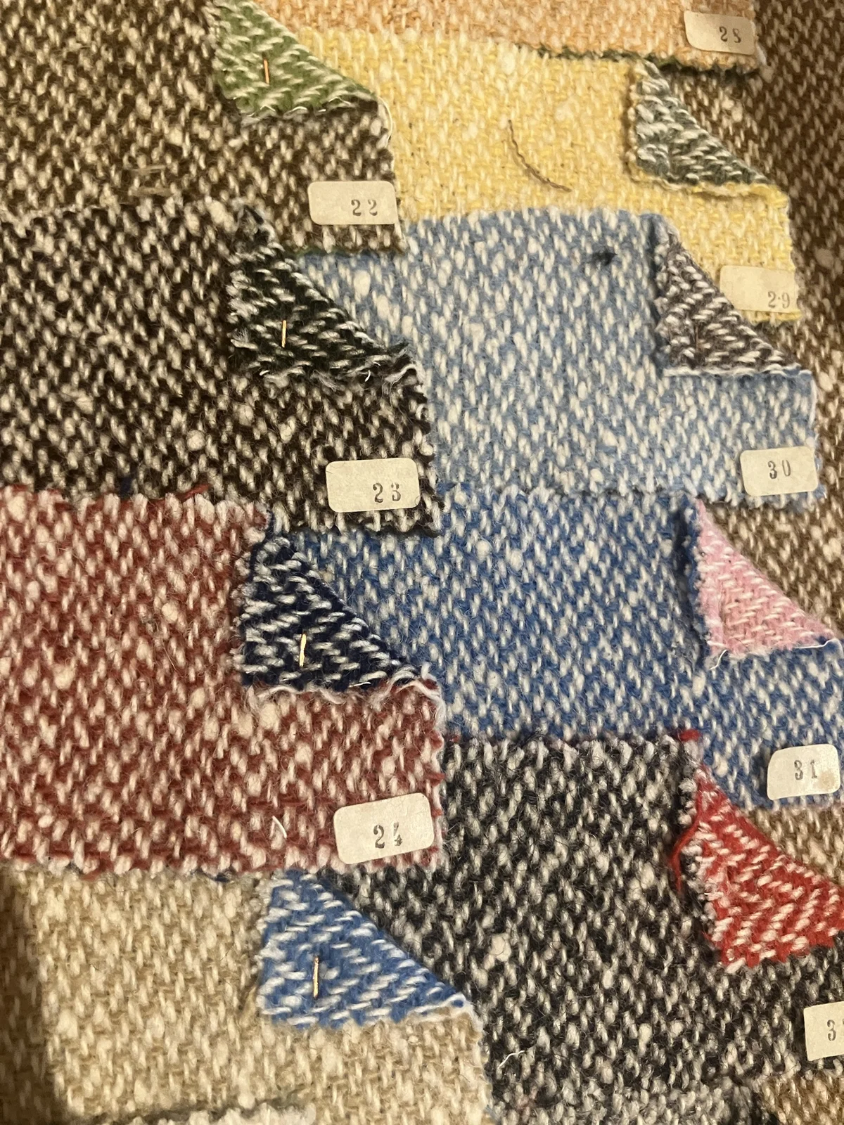 Numbered tweed swatches pinned together in the Lanificio Bottoli archive.