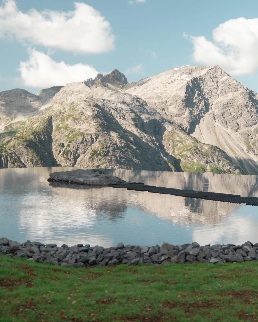 The Lech Mountain Mirror on the roof of the Zugerbergbahn mountain station, edged with stones and grass