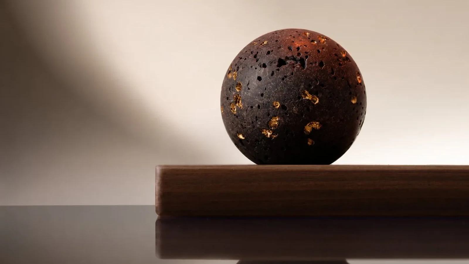 A sphere of lava from Etna's 1910 eruption, some of its pores filled with gold. A few drops on its surface scent a room. Courtesy of Spezieria Siciliana.