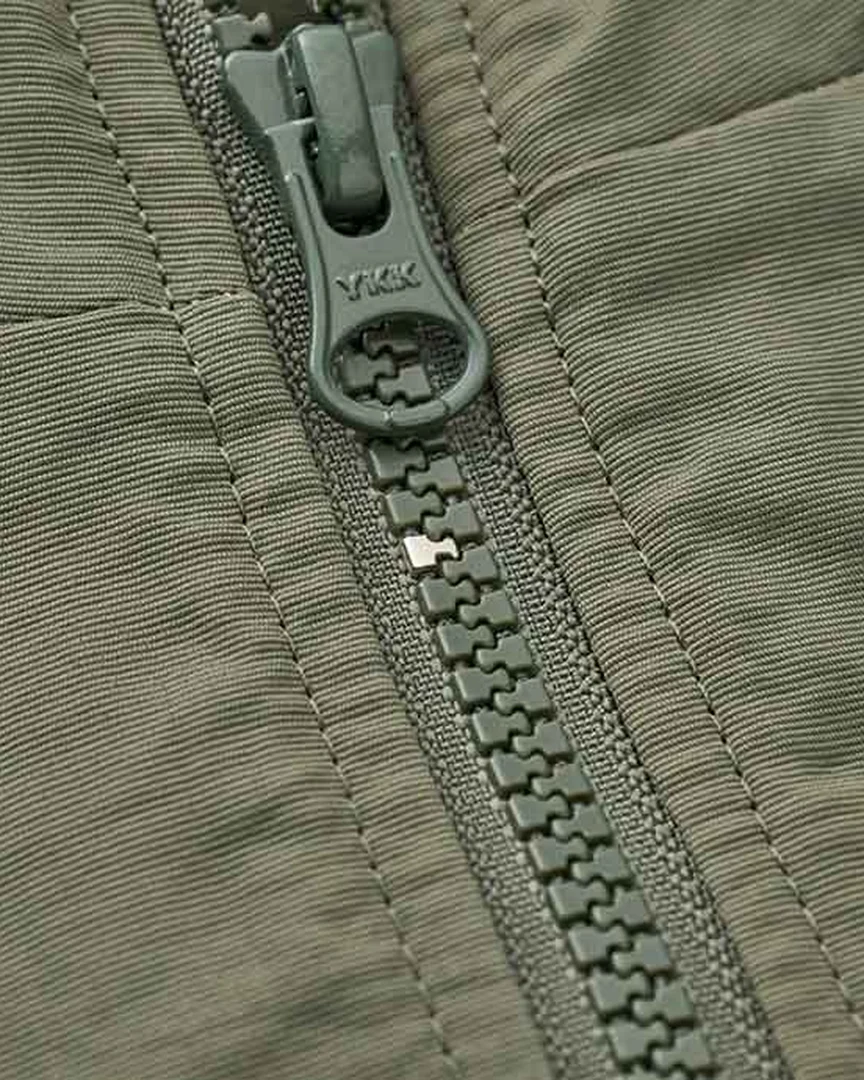 A repaired YKK VISLON zipper on an olive jacket