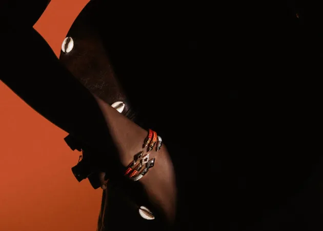 Stacked Fullord bracelets on a wrist in silhouette. Courtesy of Fullord Geneva