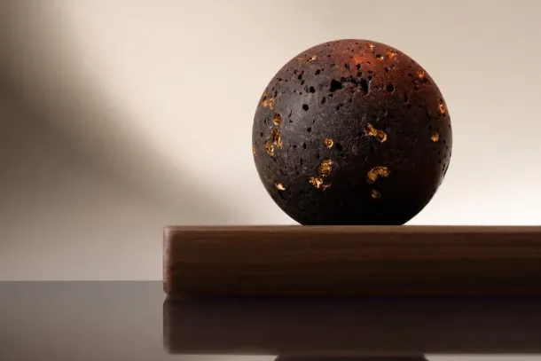 A sphere of lava from Etna's 1910 eruption, some of its pores filled with gold. A few drops on its surface scent a room. Courtesy of Spezieria Siciliana.