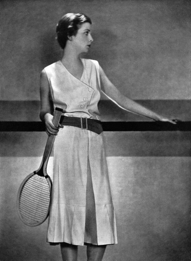 The jupe-pantalon tennis dress in light white wool with an orange tussore belt, 1930. Its divided skirt reached the public when the Spanish champion Lili de Álvarez wore Schiaparelli at Wimbledon in 1931, to considerable scandal. Credit: APA-Images / Mary Evans / Illustrated London News Ltd.