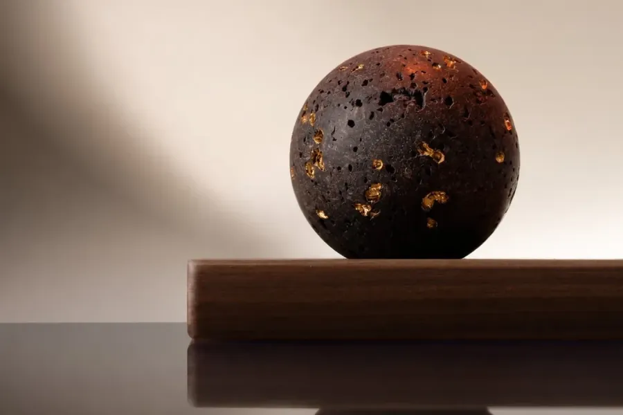 A sphere of lava from Etna's 1910 eruption, some of its pores filled with gold. A few drops on its surface scent a room. Courtesy of Spezieria Siciliana.