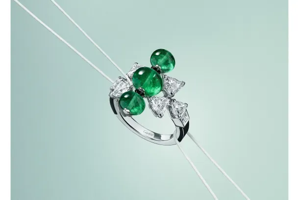 Cartier En Équilibre Summae ring in white gold with cabochon emeralds, troïdia-cut diamonds and onyx on a pale green ground. | Photo: courtesy of Cartier