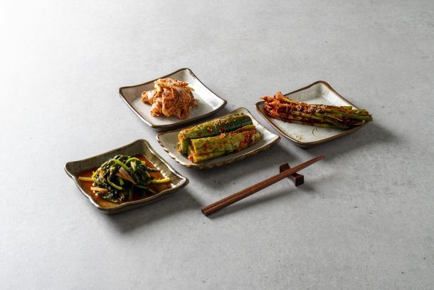 The everyday architecture of a Korean table: four kinds of kimchi, four handmade plates, one pair of chopsticks. In Busan, this is where the city begins. The Silent Luxury, June 2026. | Photo: magnific.com